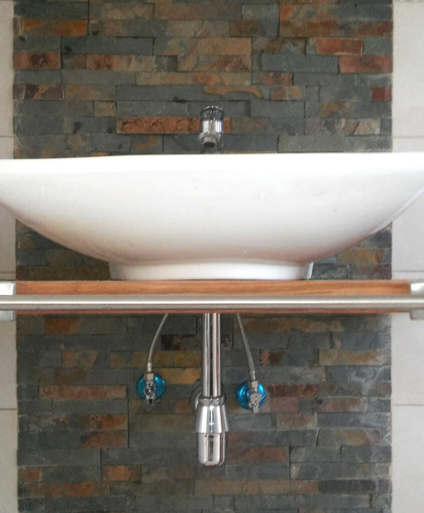 white sink on the bathroom with decorative brick wall