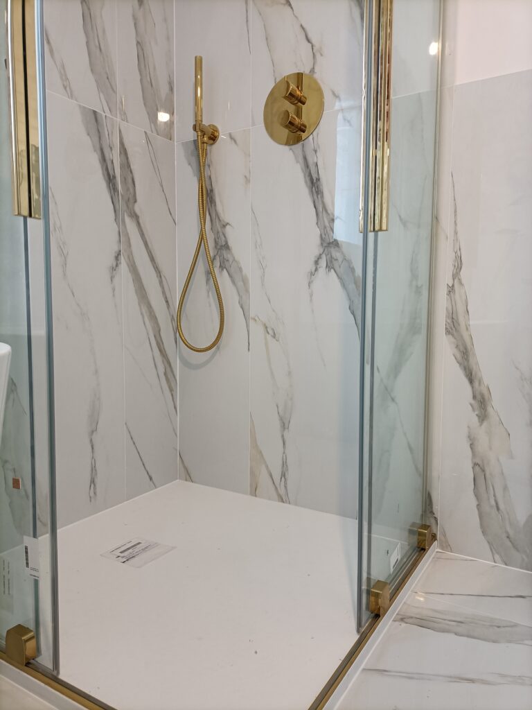 Rectangular shower cabin with glass doors and golden elements