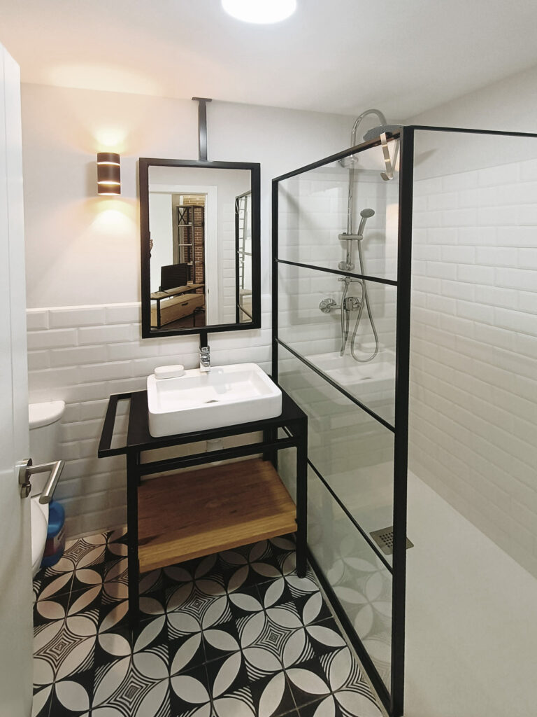 modern white bathroom with rectangular shower cabinet with white-black pattern floor