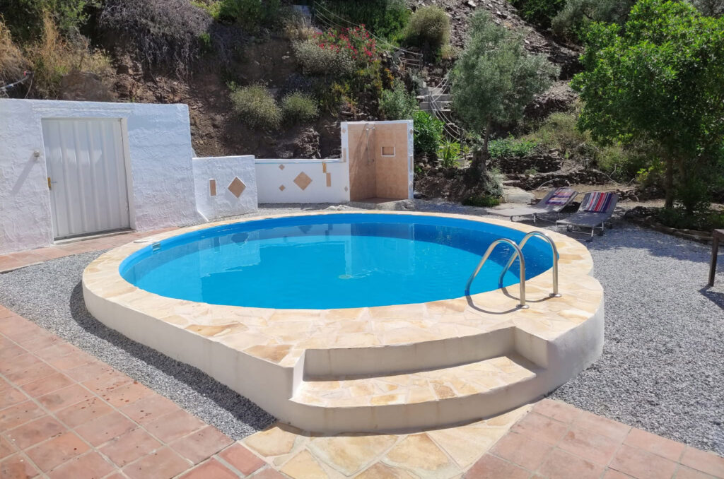 circle swimming pool with blue water located on the house on the mountains